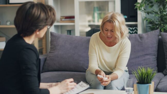Adult client seated and speaking with a therapist during a private trauma counseling session
